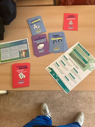 Karten und Informationsblätter auf einem Tisch, themenbezogen und bunt gestaltet.